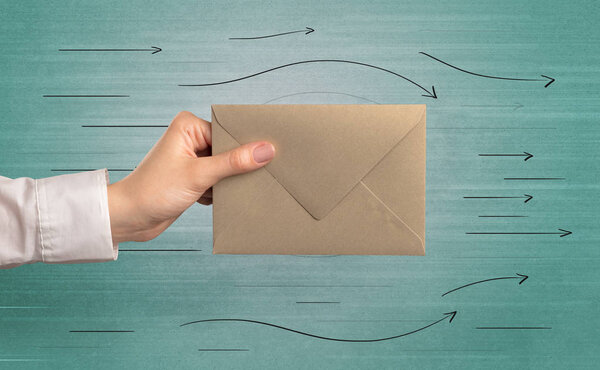 Hand holding envelope with arrows around