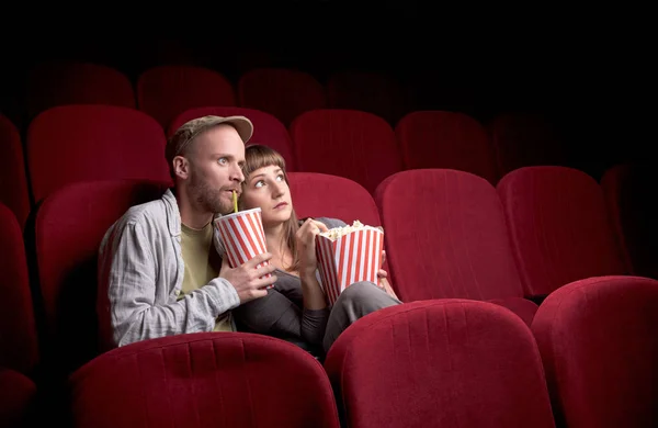 Junges Paar sitzt im roten Kino — Stockfoto