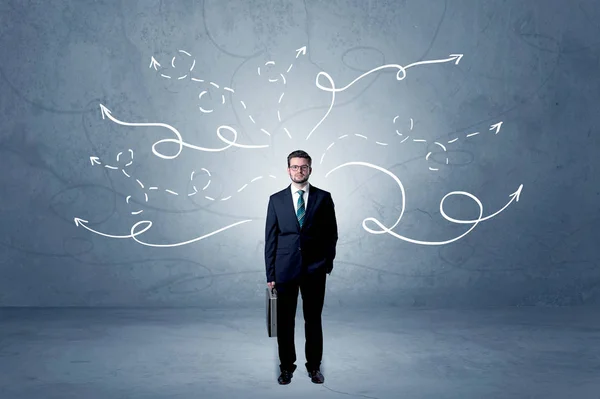 Businessman standing with winding arrows around — Stock Photo, Image