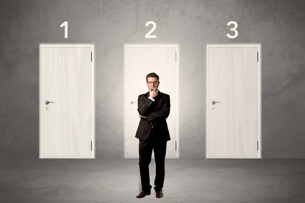 Businessman thinking in front of three doors — Stock Photo, Image