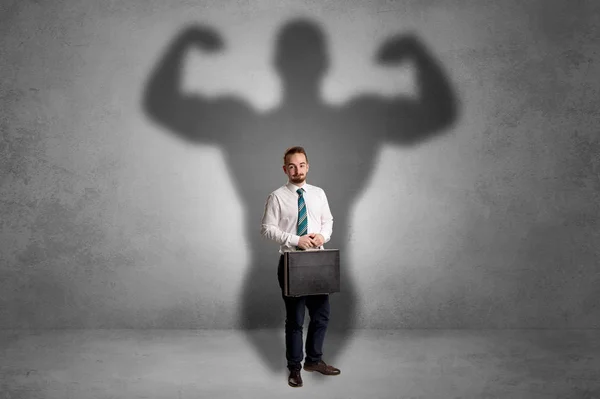 Businessman with muscular shade behind his back — Stock Photo, Image