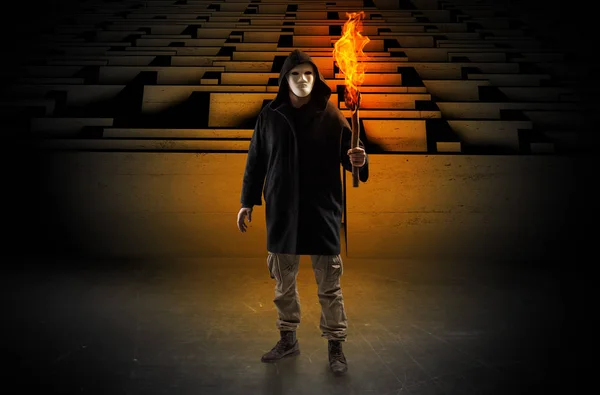 Man coming with burning flambeau from the maze concept — Stock Photo, Image