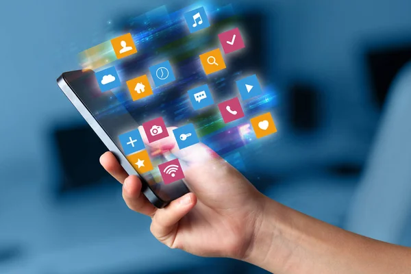 Main en utilisant le téléphone avec des icônes d'application colorées et le concept de symboles — Photo