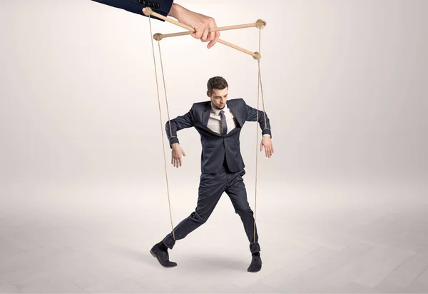 Marionet zakenman gelode door een enorme hand — Stockfoto