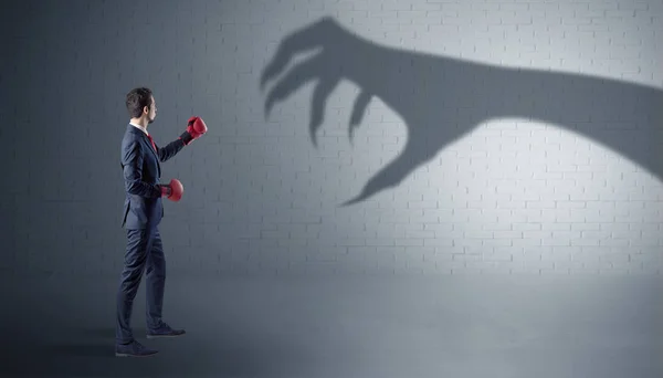 Empresário lutando com sombra de mão assustadora — Fotografia de Stock