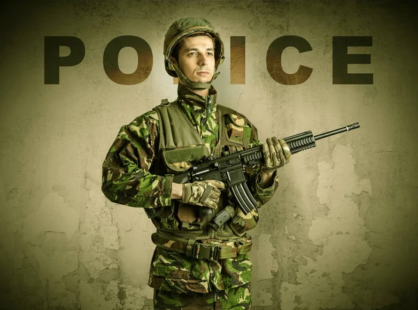 Armed soldier with damaged wall background — Stock Photo, Image