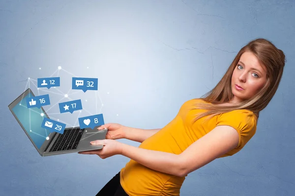 Женщина держит ноутбук с уведомлениями в социальных сетях — стоковое фото