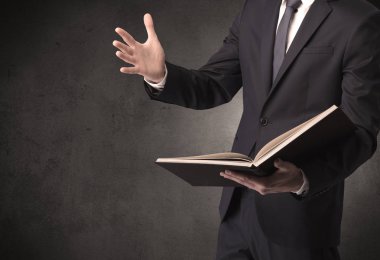 Elinde kitap tutan bir işadamı.