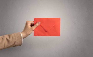 Zarf boş duvar arka plan ile tutan el