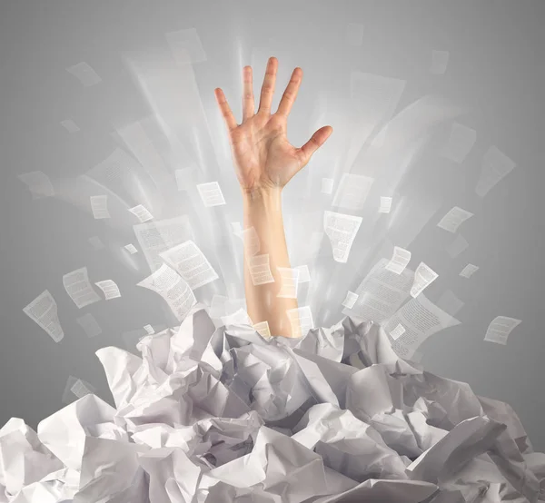 Hand coming out from paper pile — Stock Photo, Image