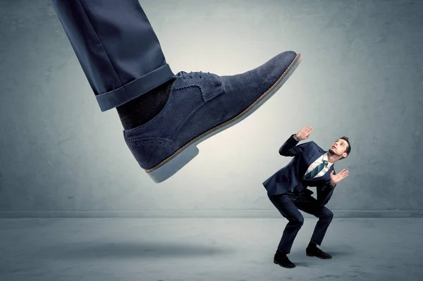 Employee getting trampled by big shoe — Stock Photo, Image