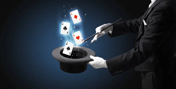 Mágico fazendo truque com varinha e jogando cartas — Fotografia de Stock