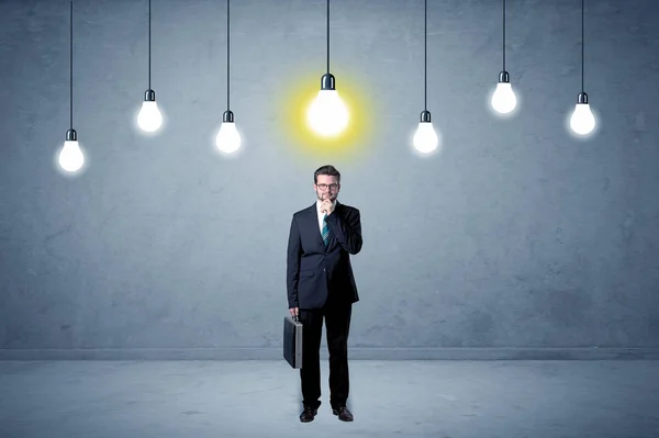Uomo d'affari in piedi senza ispirazione con lampadine sopra — Foto Stock