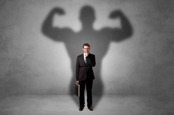 Geschäftsmann mit muskulösem Schatten hinter dem Rücken — Stockfoto