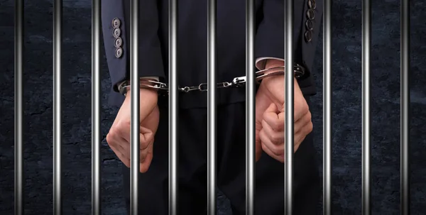 Человек в наручниках в тюрьме — стоковое фото