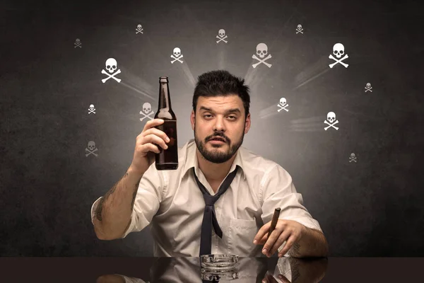 Homem bêbado sentado à mesa com crânios conceito — Fotografia de Stock