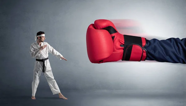 Pequeno homem lutando com grande luva de boxe vermelho — Fotografia de Stock