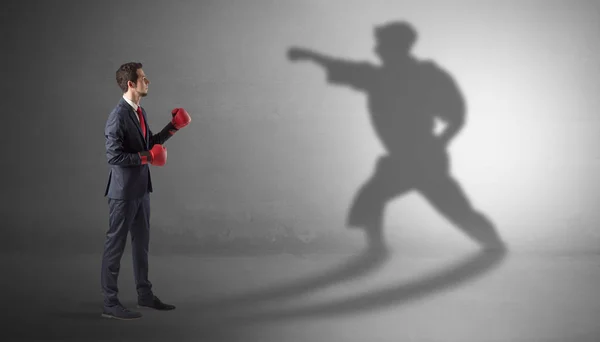 Young businessman fighting with his shadow — Stock Photo, Image