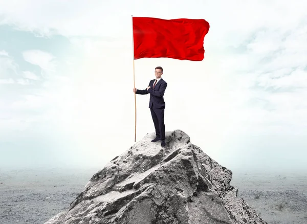 Businessman on the top of a the mountain holding flag — Stock Photo, Image