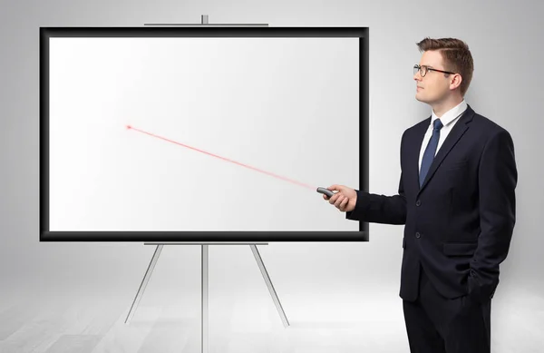 Businessman with laser pointer and copyspace white wall — Stock Photo, Image