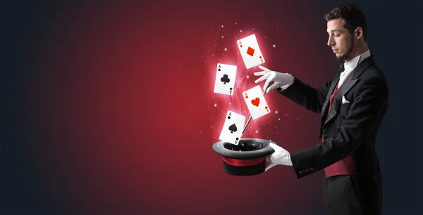 Mágico fazendo truque com varinha e jogando cartas — Fotografia de Stock