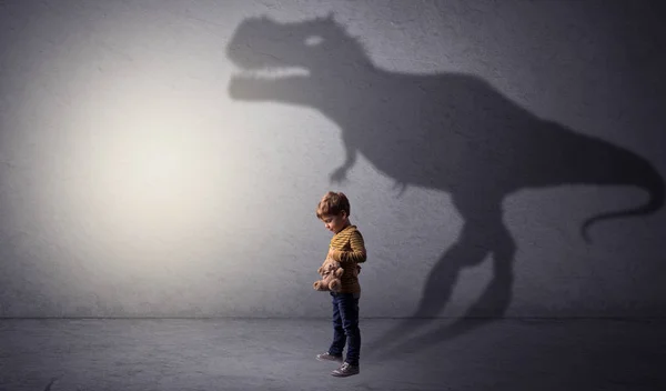 Dinosaurus shadow behind cute boy — Stock Photo, Image