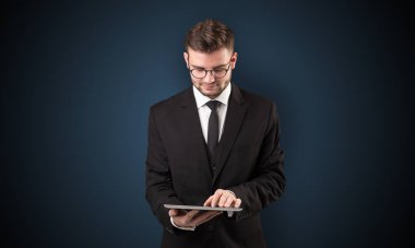 İşadamı holding tablet ile koyu arka plan