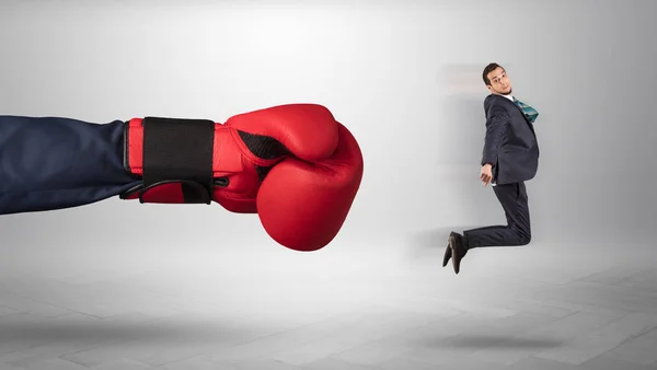 Mão gigante dá um chute a um pequeno empresário — Fotografia de Stock