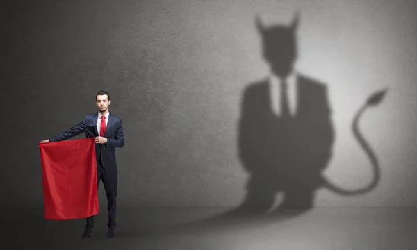 Бизнесмен с дьявольской тенью и тореадором — стоковое фото
