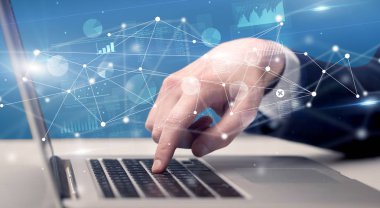 El laptop ile bağlantılı bir rapor ve grafikler çevresinde yazarak