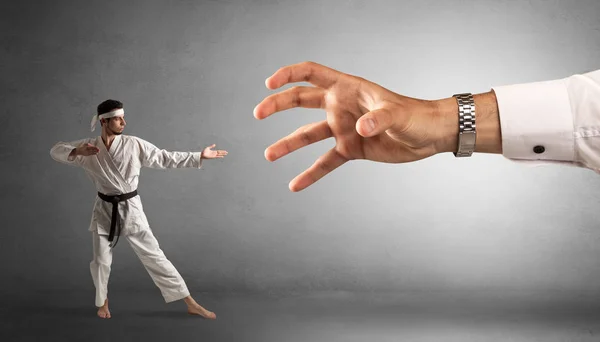 Stor hand fånga små karate man — Stockfoto