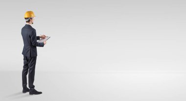 Boş bir alanda duran ve bir plan tutan mimar