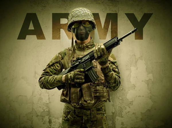 Beväpnad soldat med skadad vägg bakgrund — Stockfoto