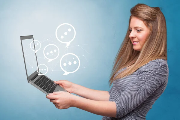 Woman holding laptop with speech bubbles — Stock Photo, Image