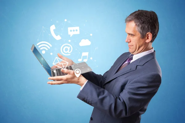 Hombre sosteniendo portátil con símbolos en línea — Foto de Stock