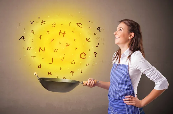 Person cooking letters in wok — Stock Photo, Image