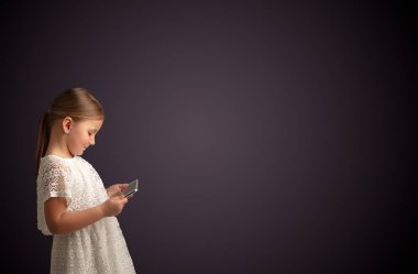 Tablet ile koyu arka plan kullanarak sevimli küçük kız