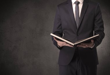 Elinde kitap tutan bir işadamı.