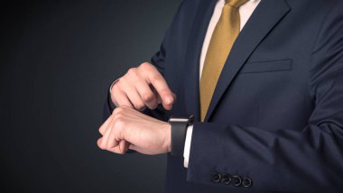 Smartwatch giyen takım elbiseli adam.