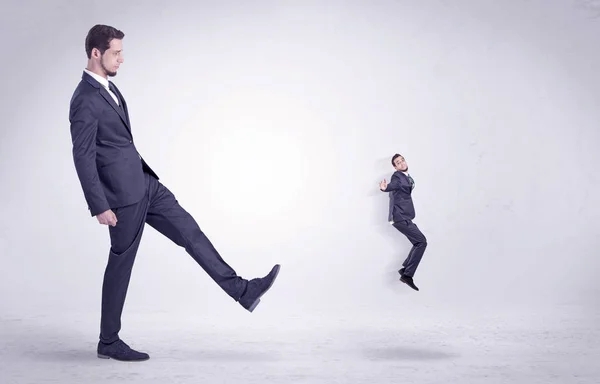 Gran hombre pateando poco a sí mismo fuera — Foto de Stock