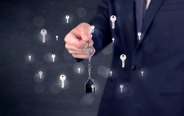 Empresario sosteniendo llaves con llaves alrededor — Foto de Stock