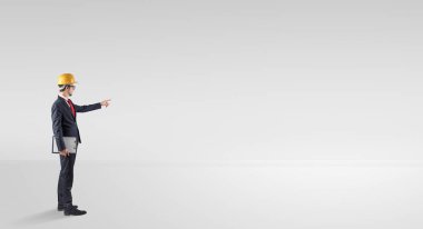 Boş bir alanda duran ve bir plan tutan mimar