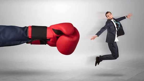 Giant hand gives a kick to a small businessman — Stock Photo, Image