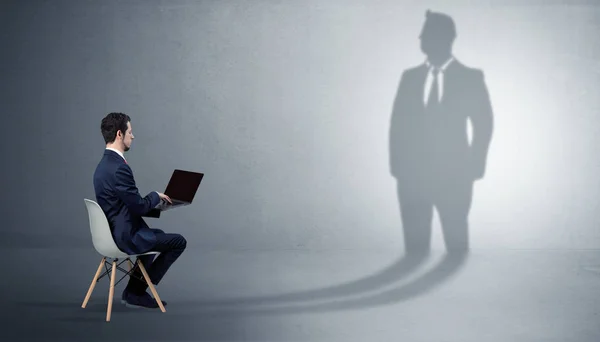 Businessman staying and offering stuffs to a huge businessman shadow — Stock Photo, Image