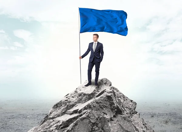 Empresario en la cima de una bandera de la montaña — Foto de Stock