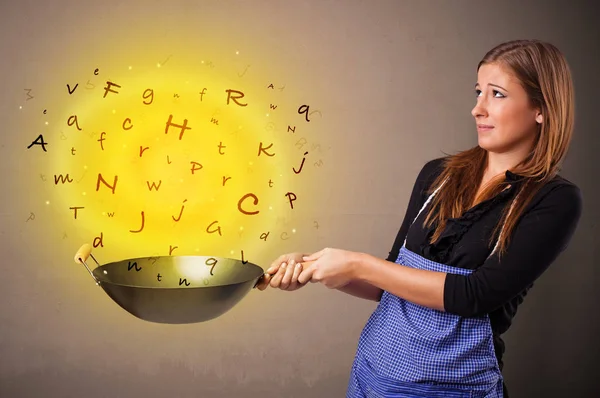 Person cooking letters in wok — Stock Photo, Image