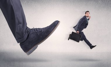 Küçük iş adamı tarafından büyük ayakkabı tekme