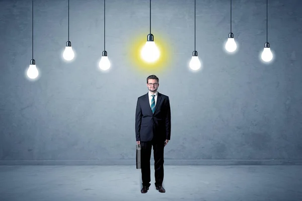 Businessman standing uninspired with bulbs above — Stock Photo, Image