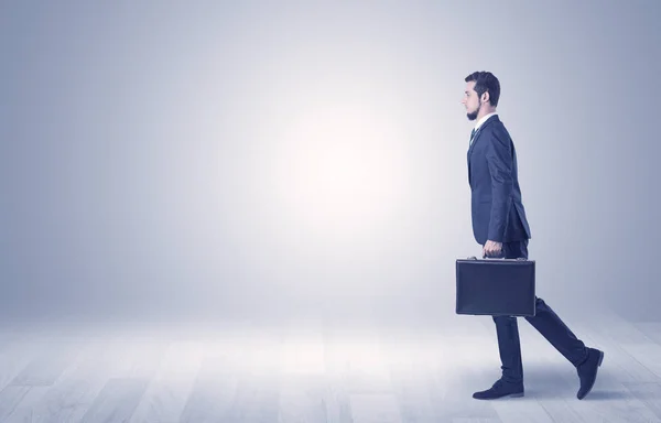 Empresario caminando frente a una pared vacía — Foto de Stock