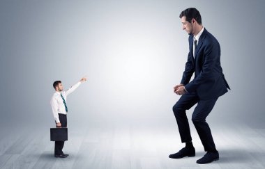 Dev bir işadamı için işaret eden küçük iş adamı